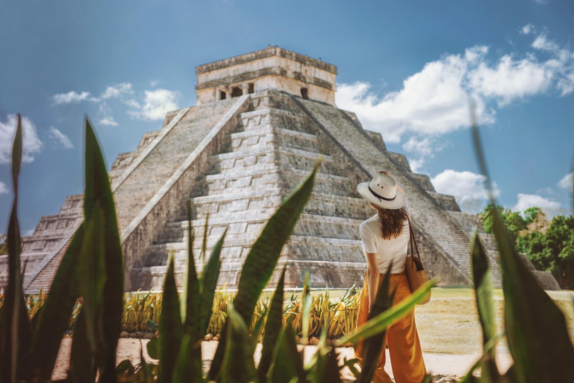 mujer con sombrero visitando la pirámide chichén itzá