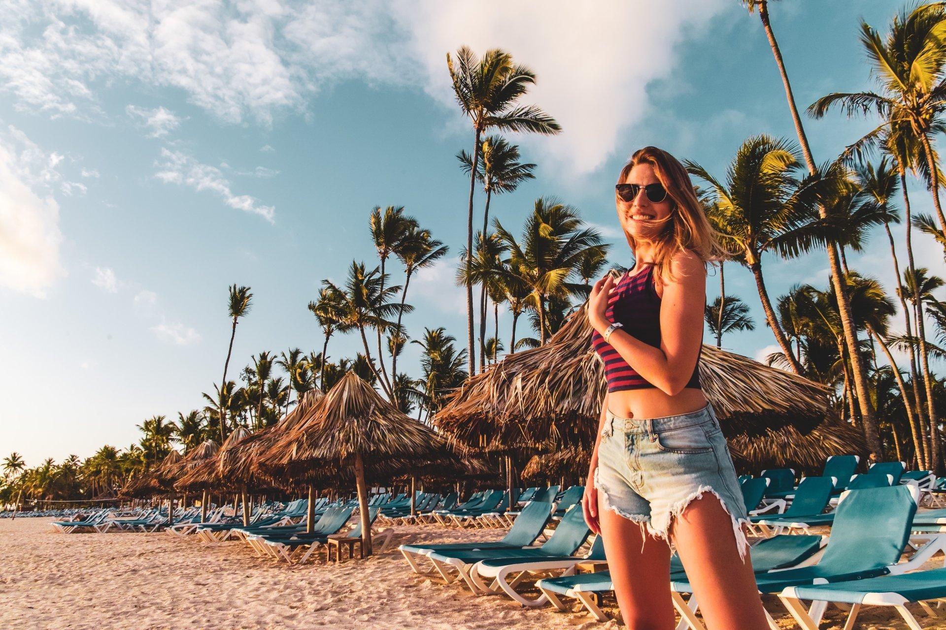 mujer con gafas de sol sonriendo en la playa de Punta Cana